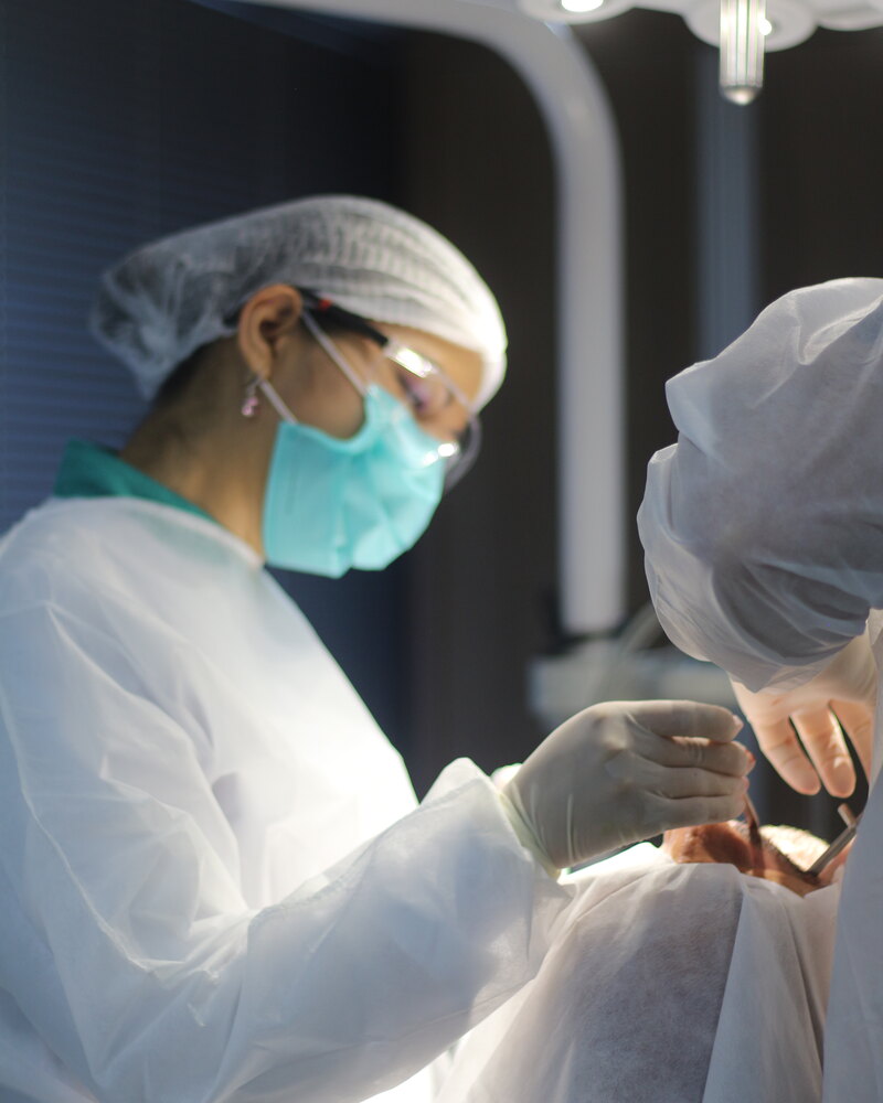Cirurgia em andamento na Oral Unic Campo Grande — ambiente cirúrgico com refletor odontológico