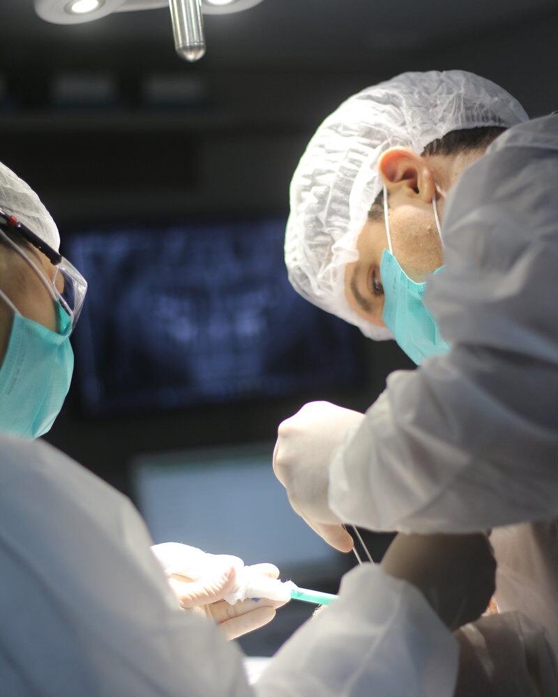 Equipe Oral Unic Campo Grande em cirurgia com raio-X panorâmico no monitor